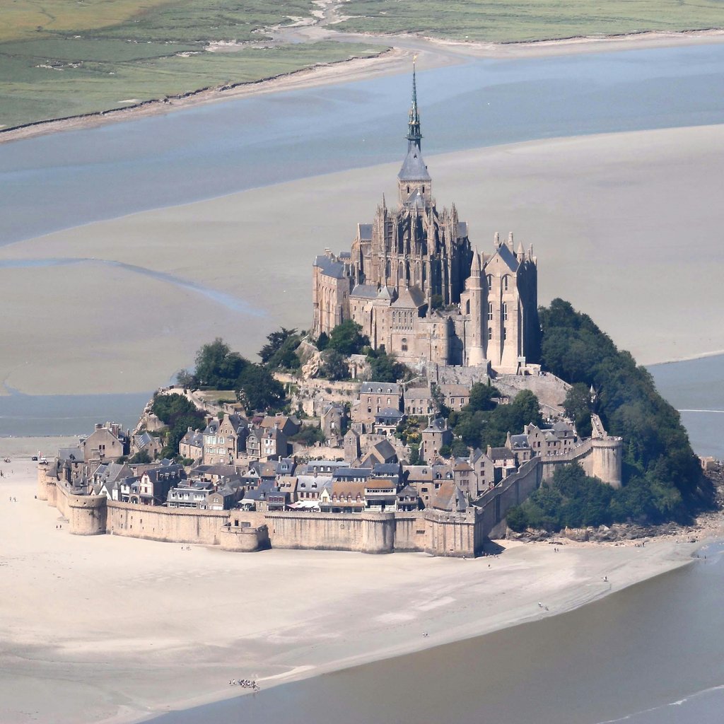 Stunning aerial shot of the iconic Mont Saint-Michel surrounded by tidal waters in Normandy, France.