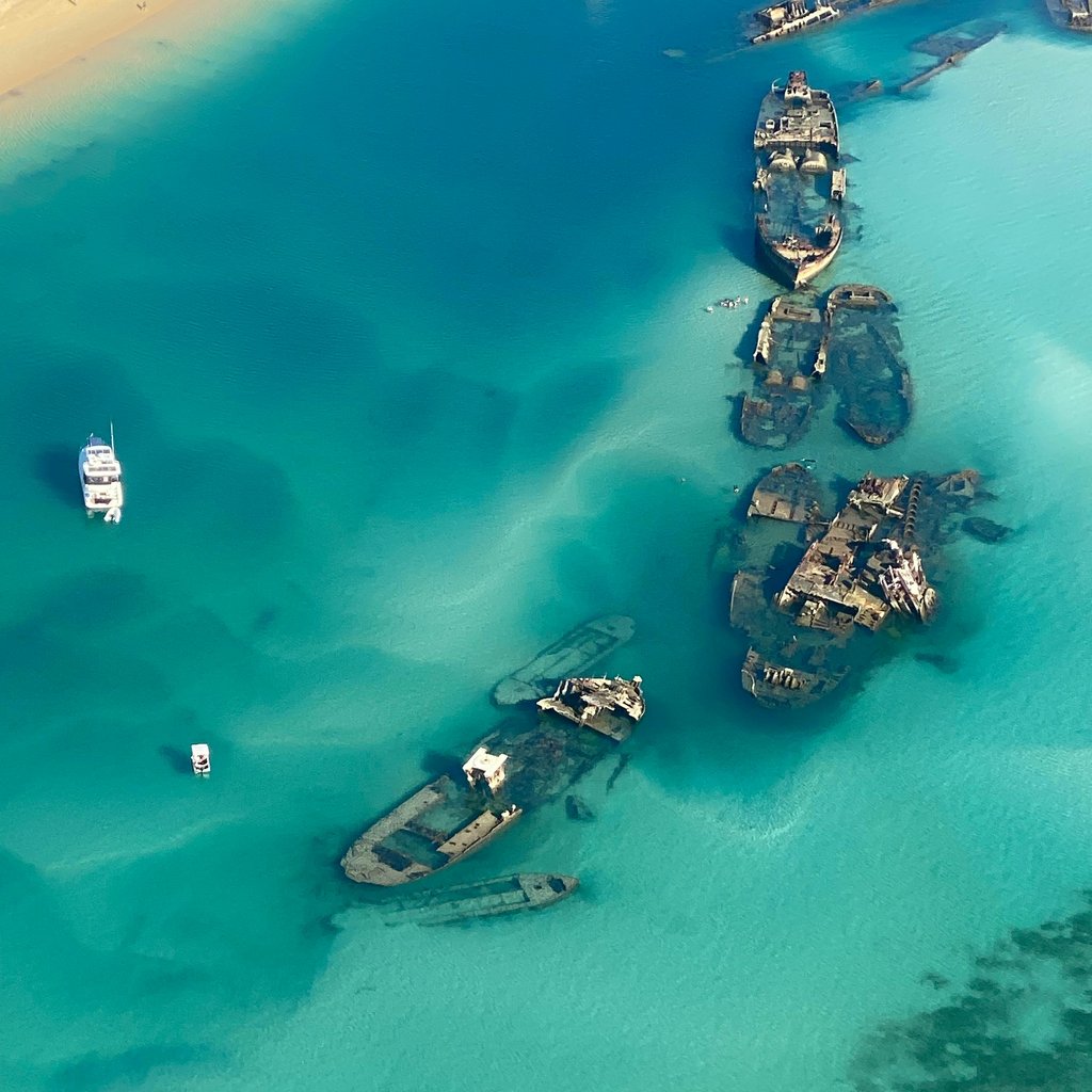 Aerial shot of shipwrecks in turquoise waters of Moreton Island, Australia.