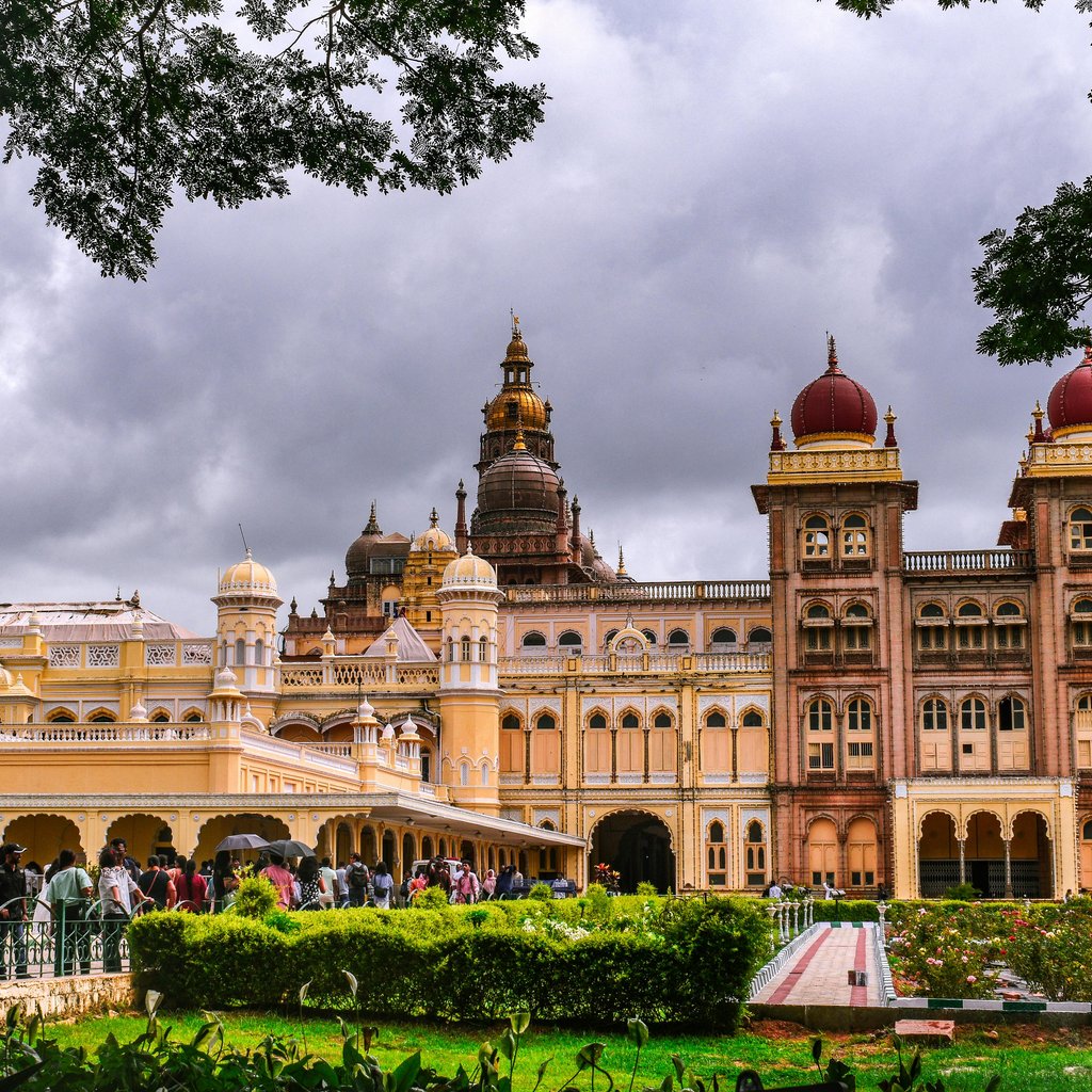 Stunning view of the Mysore Palace, a famous landmark in Mysuru, India, under dramatic clouds.