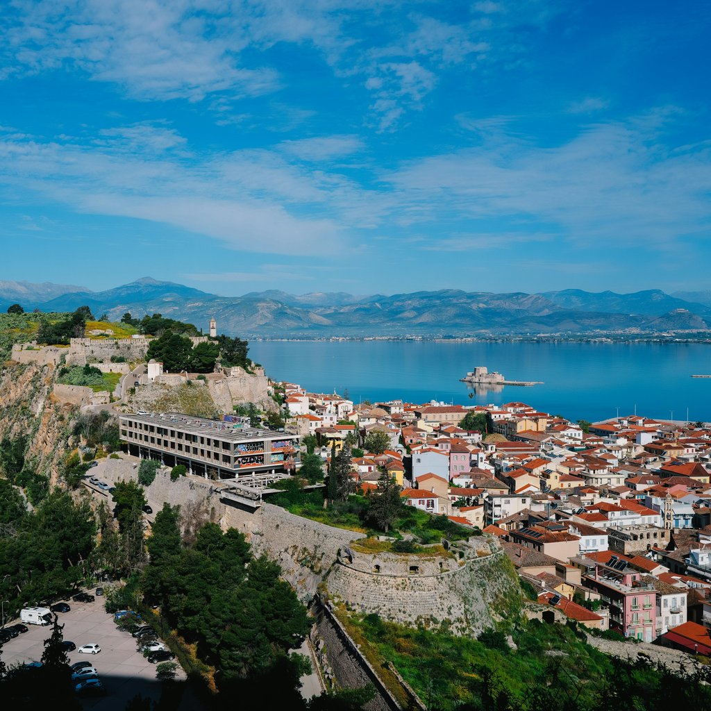 Aerial view of Nafplio, Greece, showcasing a historic fortress and vibrant seascape.