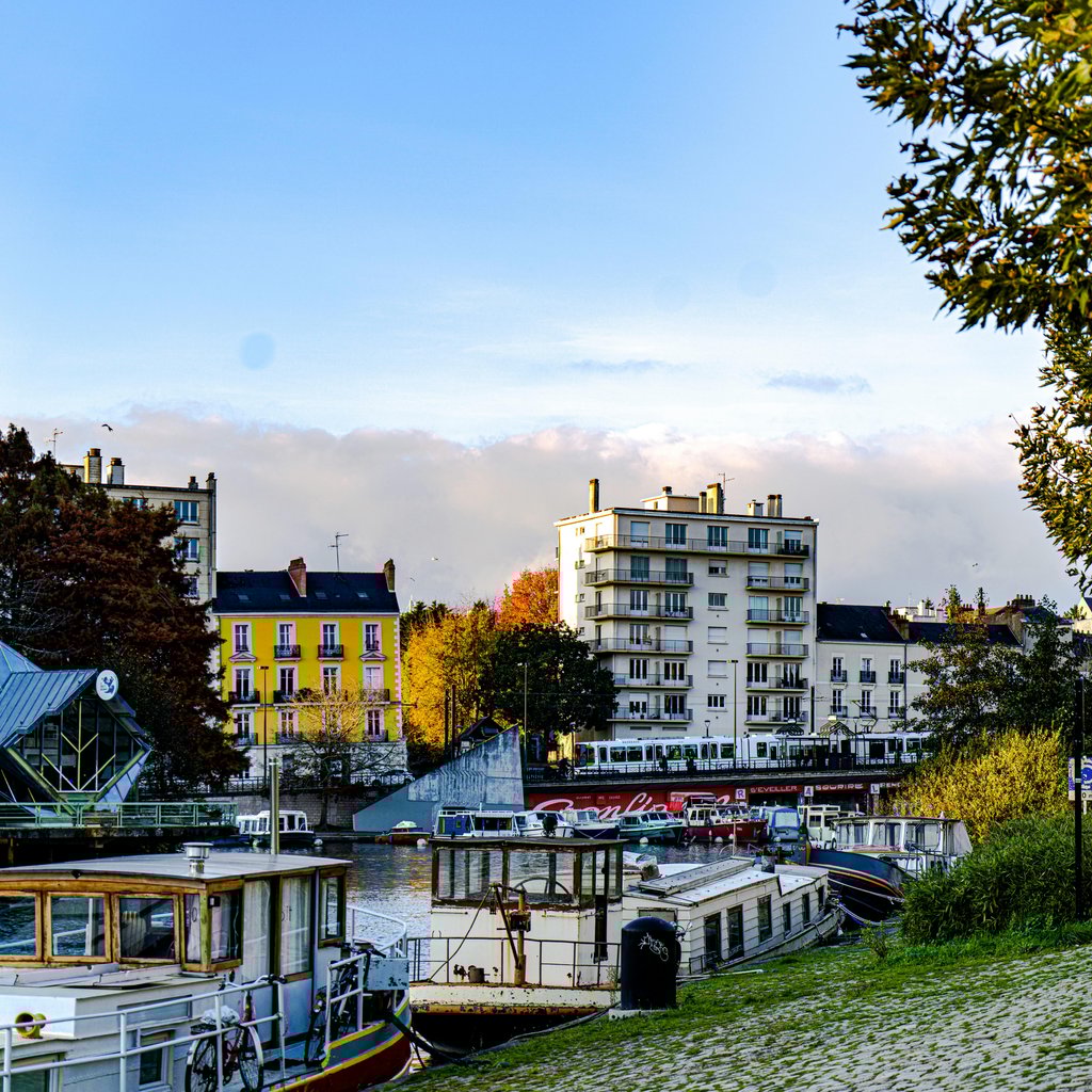Charming riverside view of Nantes, France, showcasing boats, buildings, and autumn scenery.