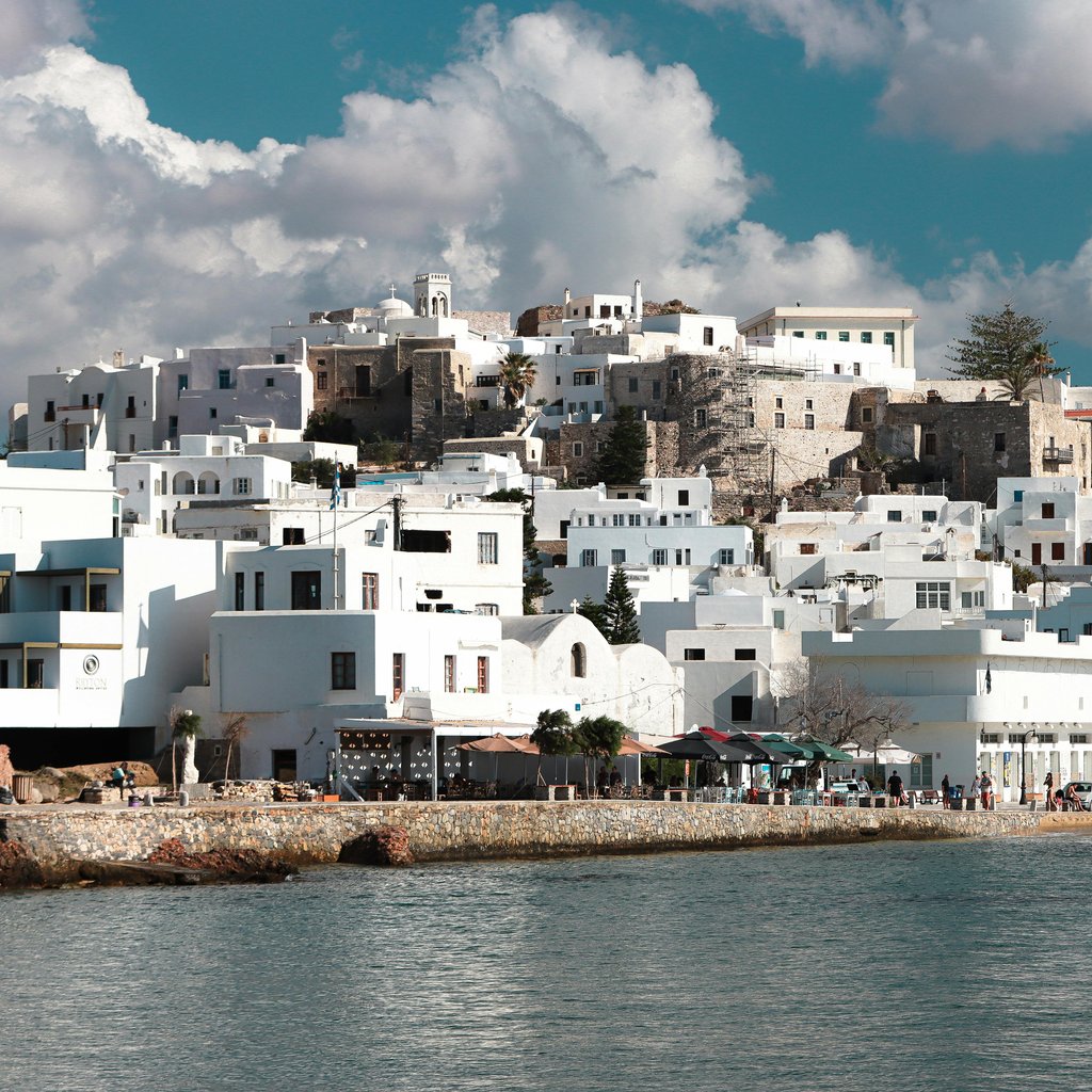 Scenic view of traditional white houses and azure sea in Naxos, Greece.