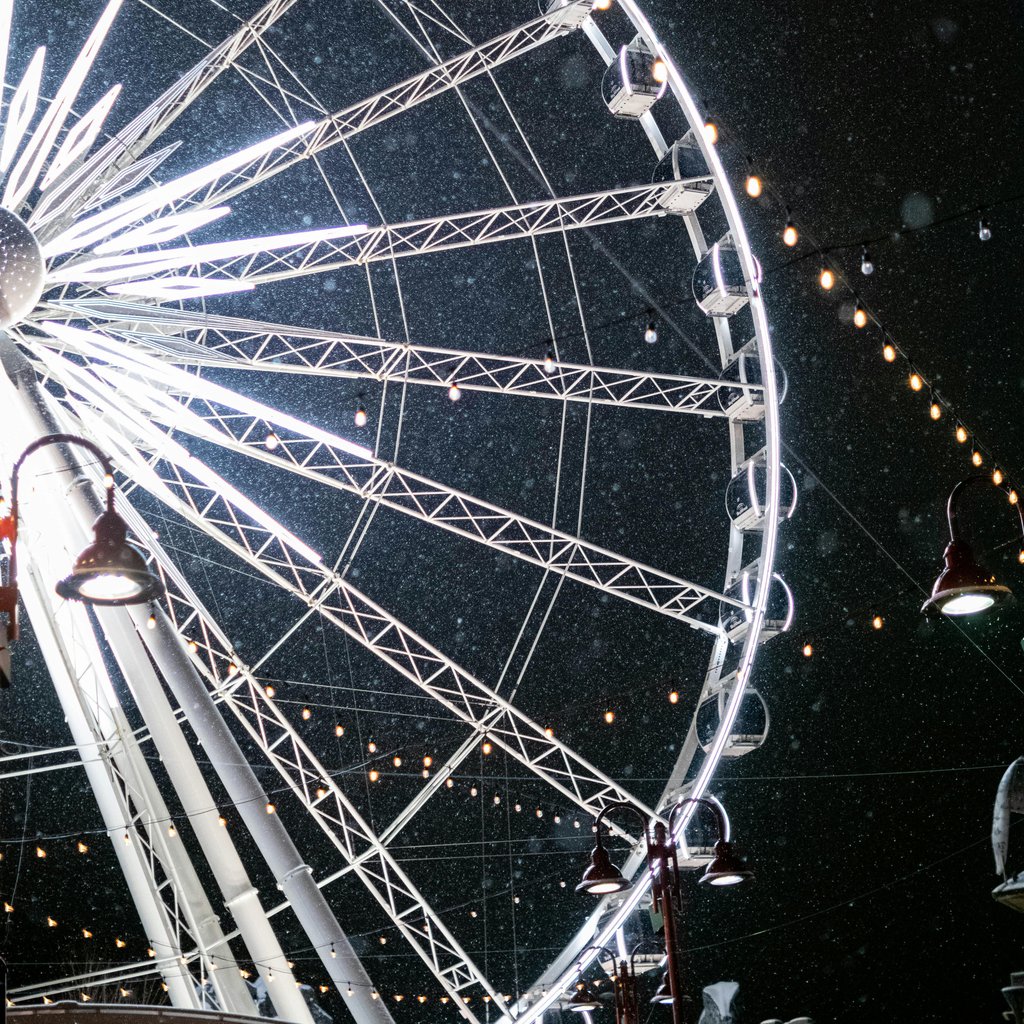 A striking view of an illuminated ferris wheel against a nighttime sky in Niagara-on-the-Lake, Ontario.