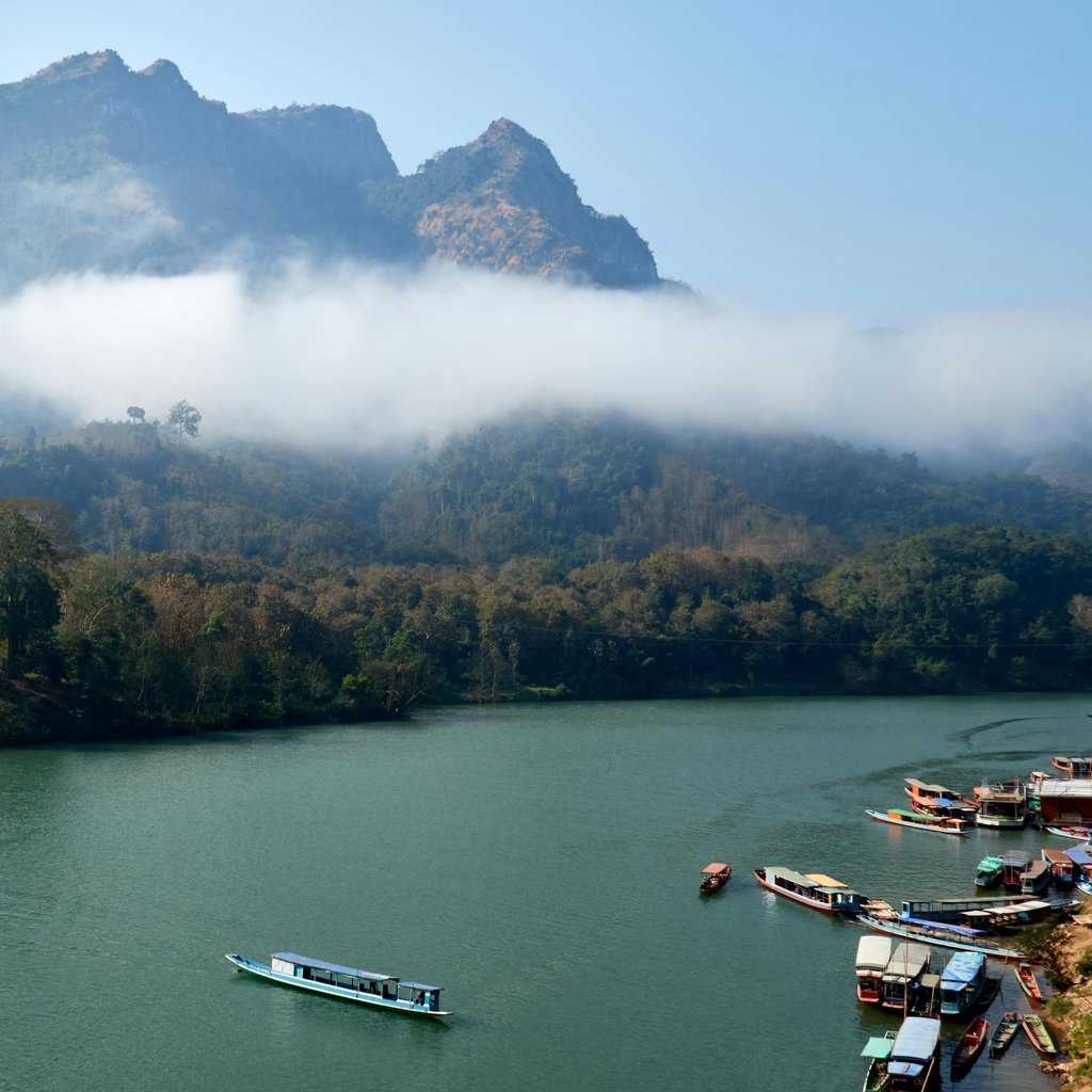 Breathtaking view of misty mountains and serene river in Nong Khiaw, Laos. Perfect for travel and nature enthusiasts.