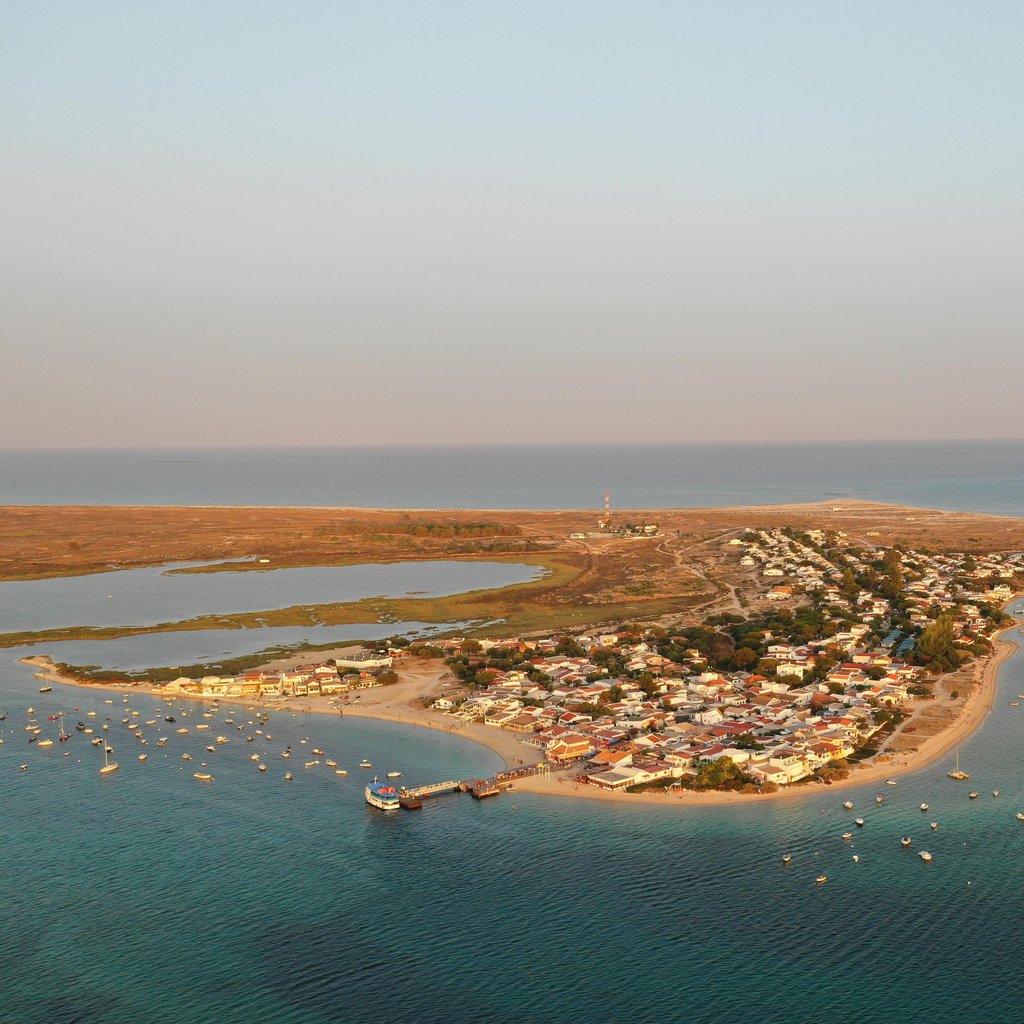 Stunning aerial shot of a coastal town in Olhão, Portugal, at sunset.