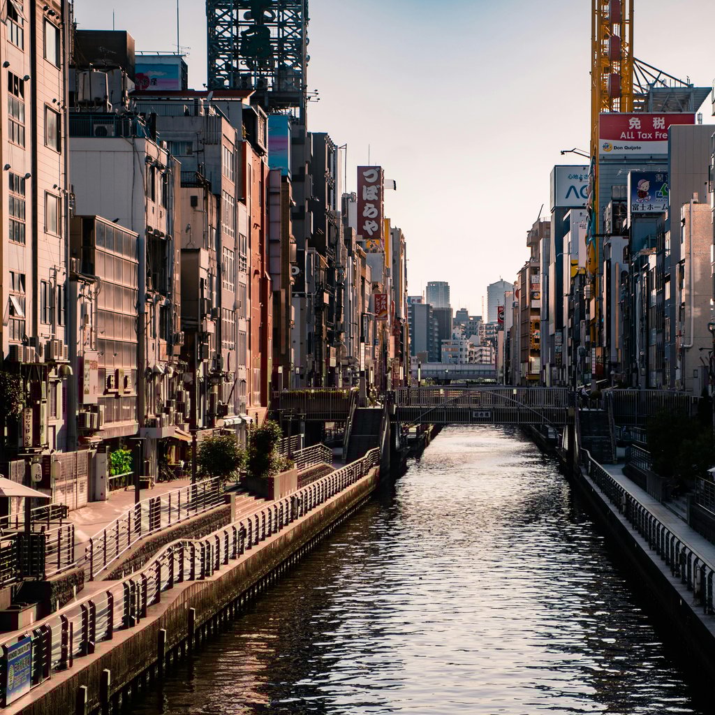 Captivating view of Dotonbori Canal in Osaka at sunset, highlighting urban architecture and vibrant city life.