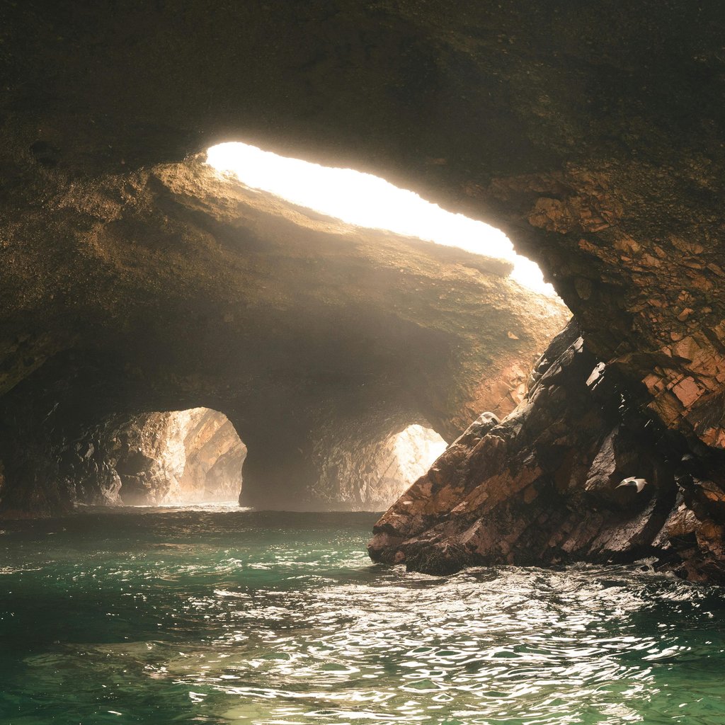 Sunlight streams into a serene cave on the Ballestas Islands in Peru.