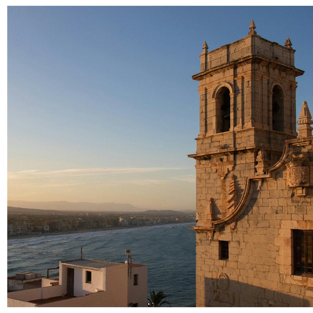 A picturesque view of Peñíscola Castle at sunset overlooking the Mediterranean Sea in Spain.