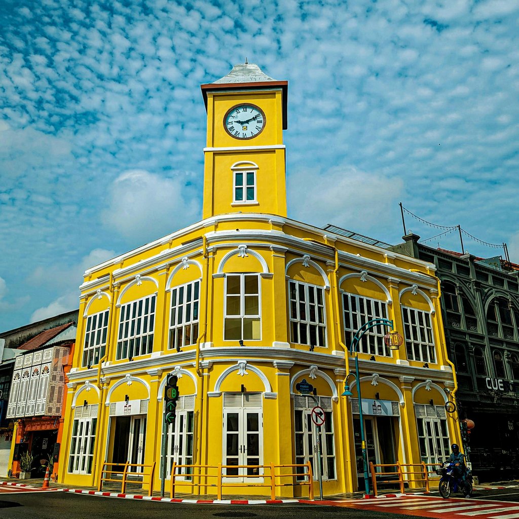 Stunning yellow colonial building with clock tower in Phuket Old Town, Thailand.