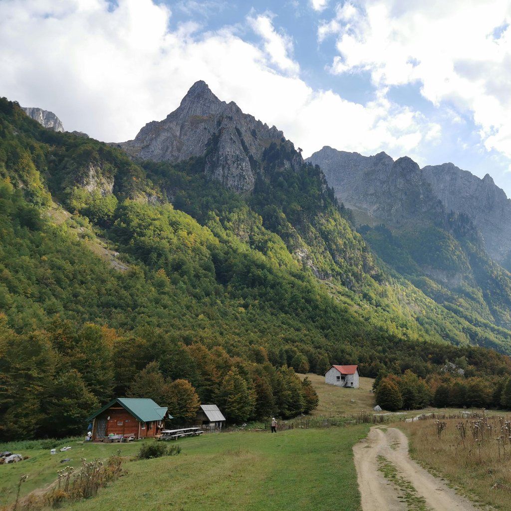 Picturesque view of rugged mountains and rustic village in Gusinje, Montenegro.