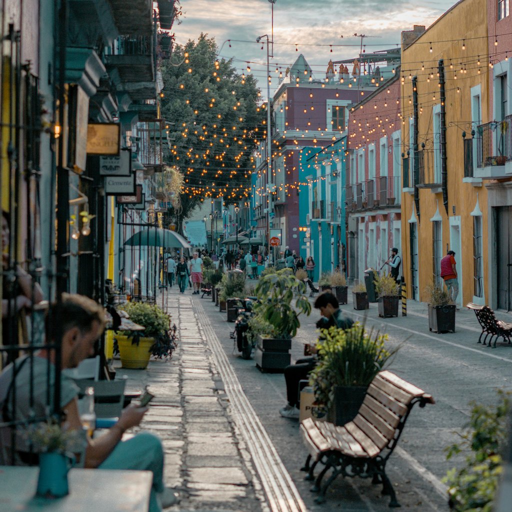 Charming street in Puebla, Mexico with vibrant buildings and string lights, capturing a lively evening ambiance.