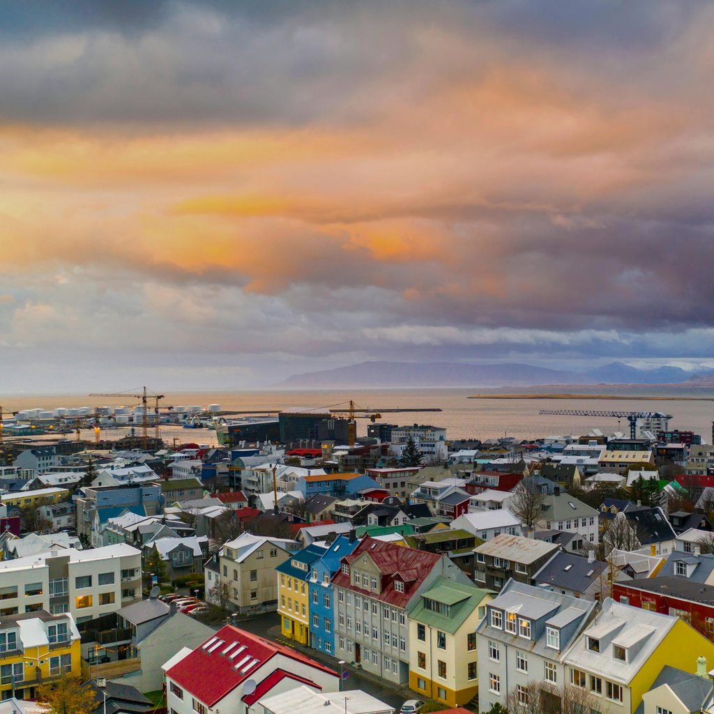 Aerial view of Reykjavik, Iceland, showcasing colorful houses and a stunning sunset.
