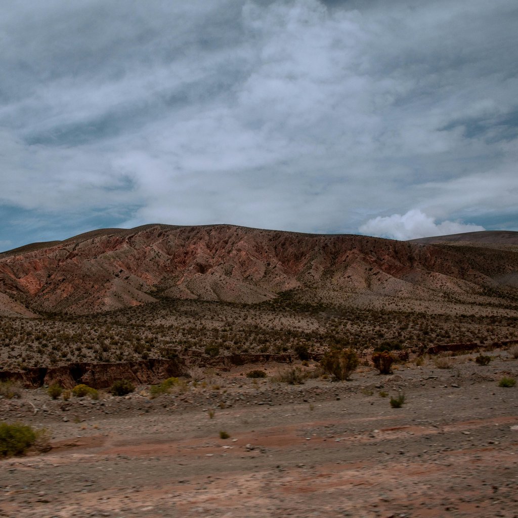 Vast desert landscape with rugged hills and cloudy sky in Salta, Argentina.