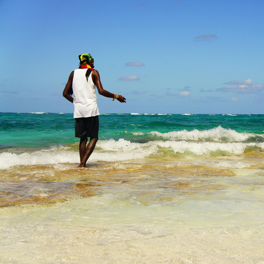 A lone fisherman casts his line in the clear blue waters at San Andrés, Colombia.