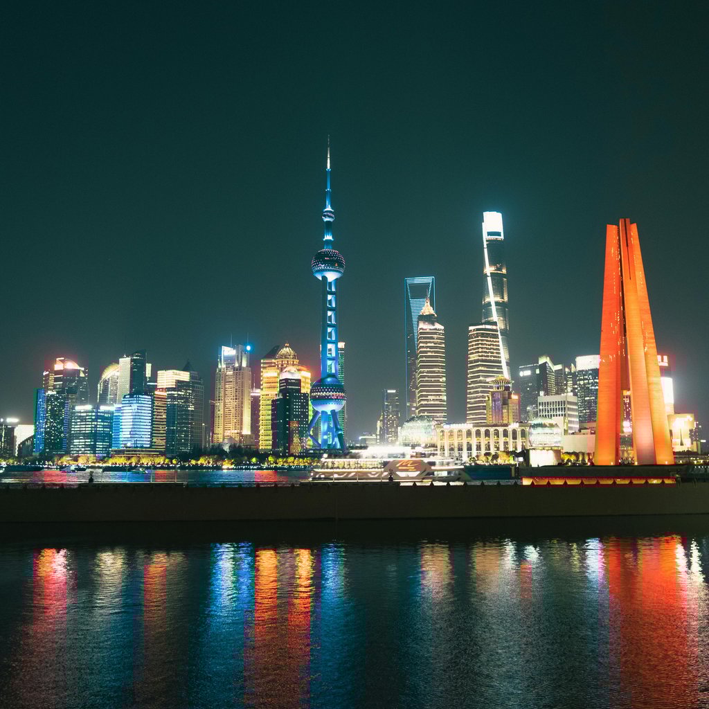 Stunning night view of Shanghai's skyline with illuminated skyscrapers and reflections.