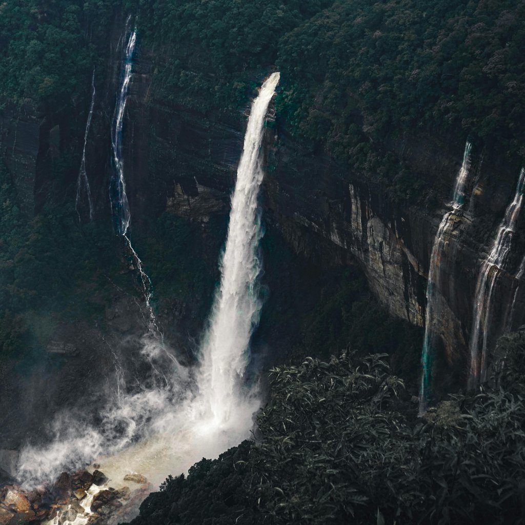A breathtaking view of waterfalls cascading in the lush forests of Shillong, India.