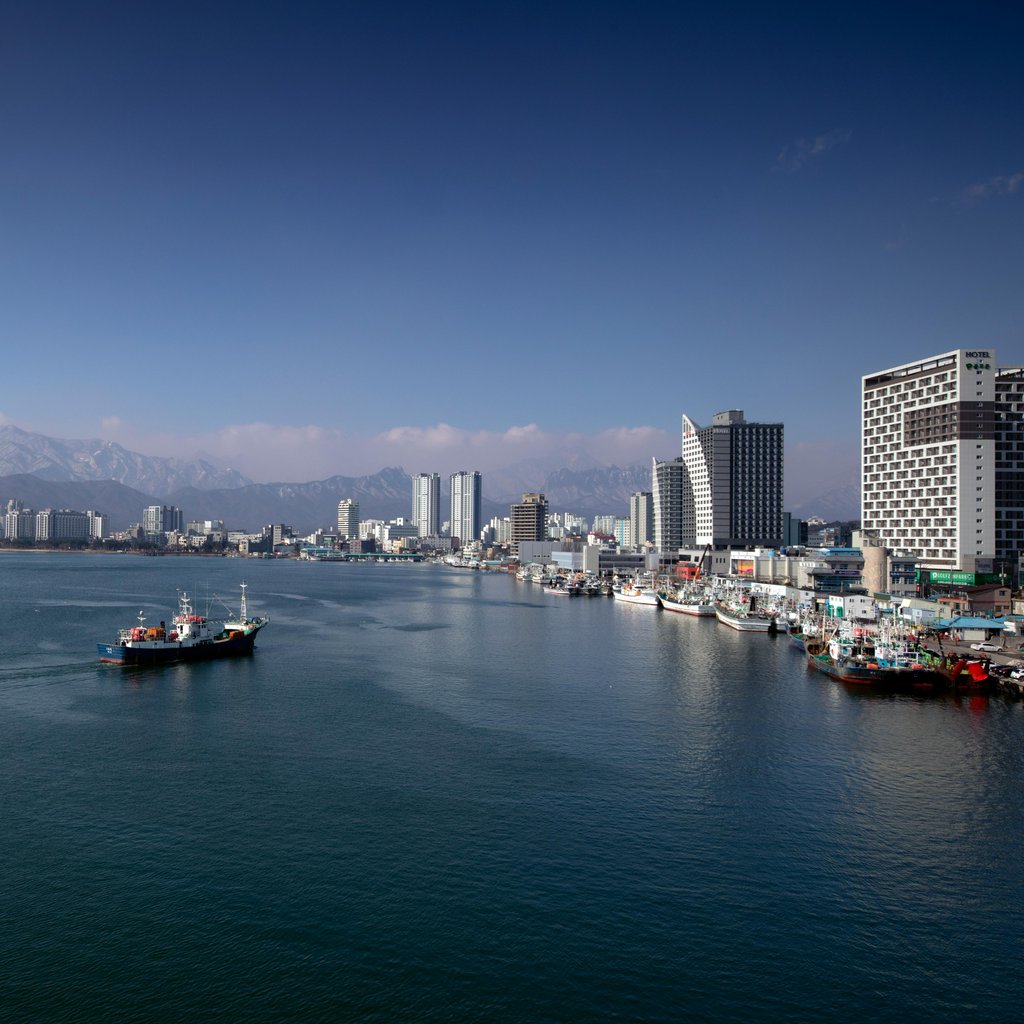 A vivid aerial shot capturing the vibrant port and skyline of Sokcho, South Korea.