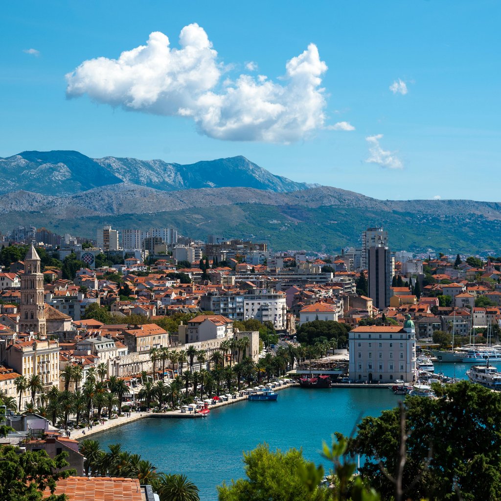 Vibrant aerial view of Split, Croatia, showcasing the coastline, harbor, and surrounding mountains.