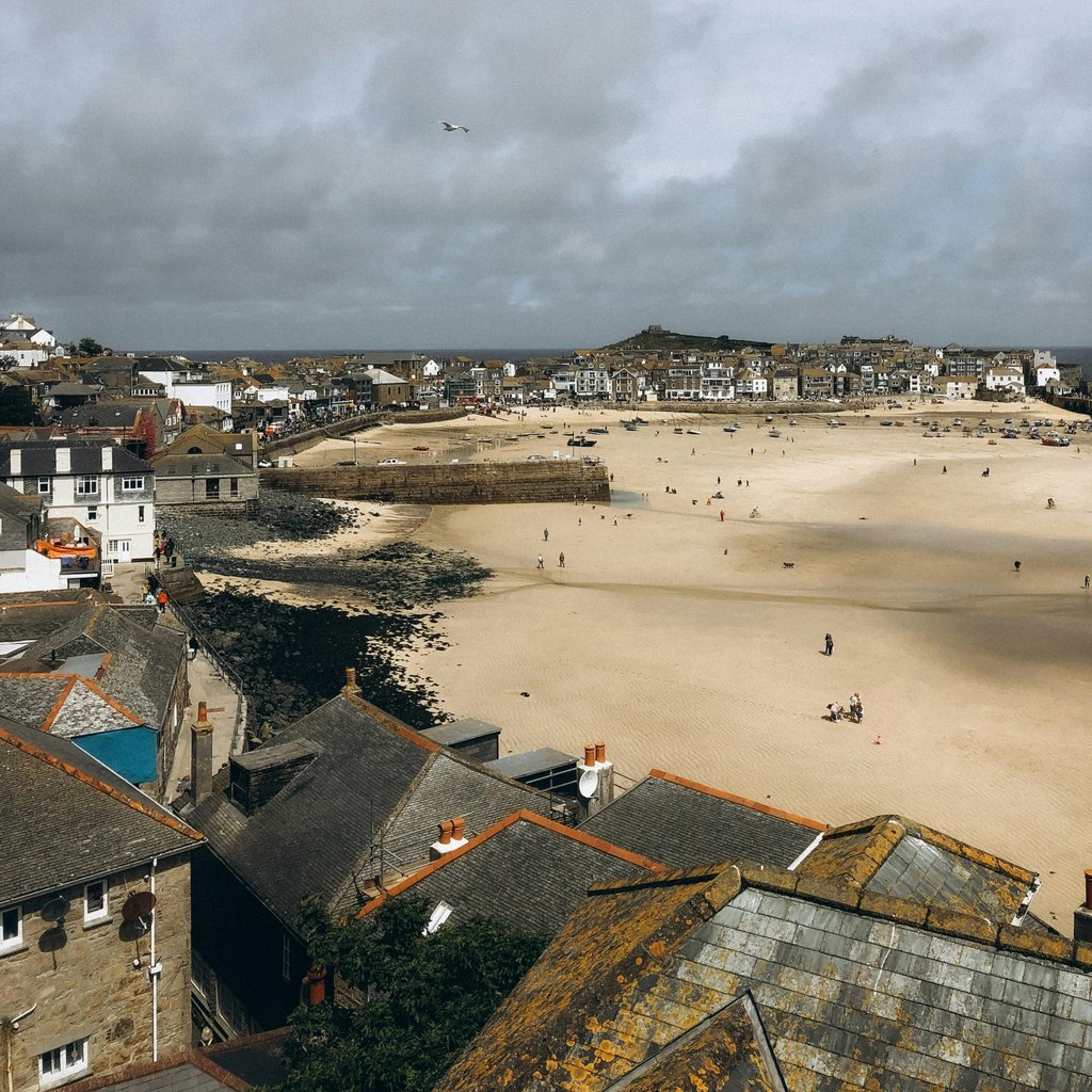 Explore the stunning aerial view of St Ives beach town in England, showcasing sandy shores and coastal architecture.