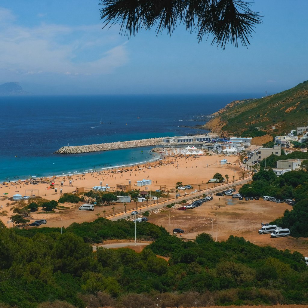 A breathtaking view of Tangier's vibrant beach and surrounding landscape under a clear blue sky.