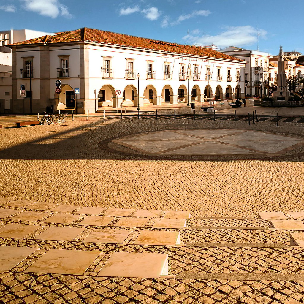 Beautiful view of the historic city square and municipal building in Tavira, Portugal, under clear skies.