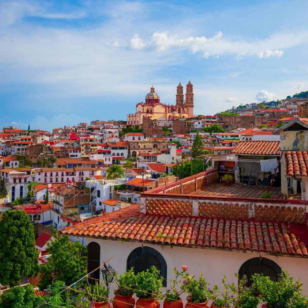 Charming aerial view of Taxco's traditional architecture against a vibrant blue sky.