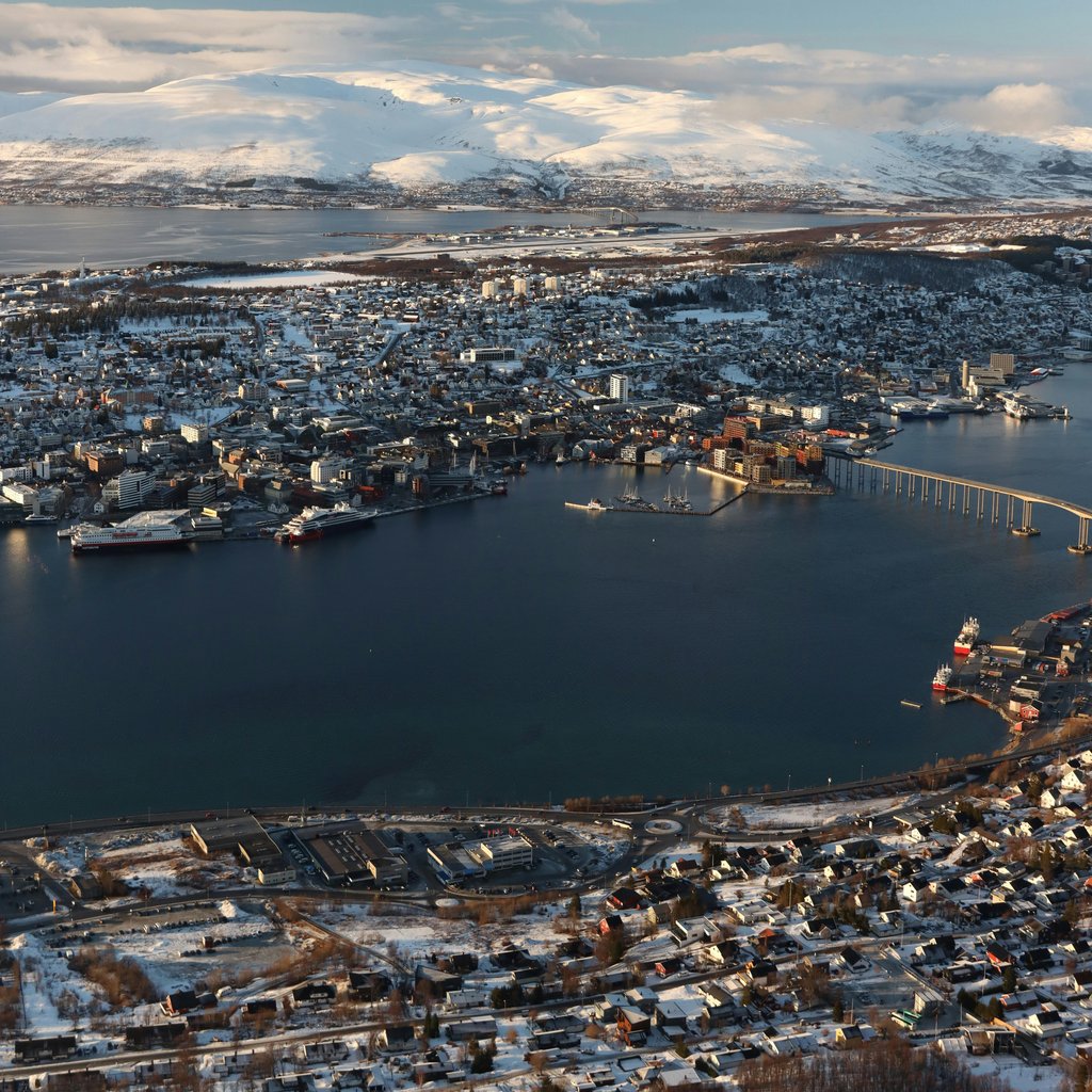 A captivating aerial view of Tromsø, Norway, showcasing its stunning snowy cityscape and surrounding landscapes.