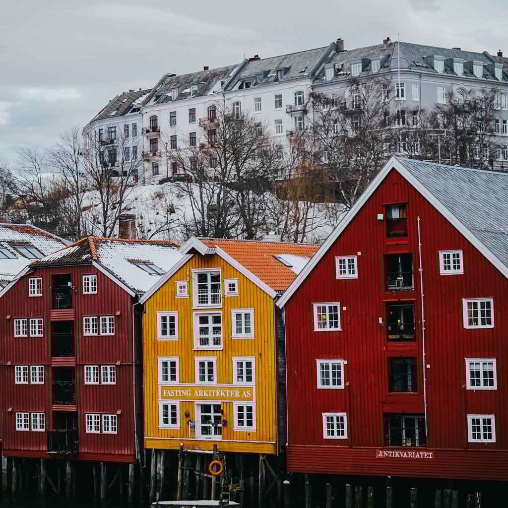 Vibrant waterfront homes in snowy Trondheim, Norway. Perfect winter urban scene.