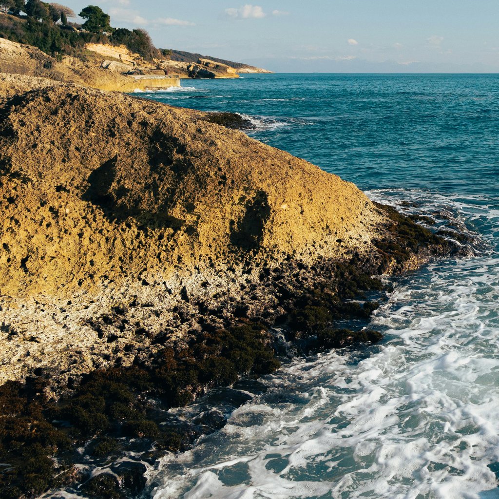 Breathtaking rocky coastline of Ulcinj, Montenegro with clear blue waters and sunny skies.