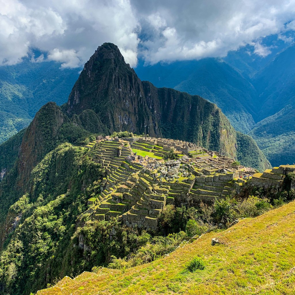 A breathtaking view of Machu Picchu in Peru surrounded by lush mountains and clouds.