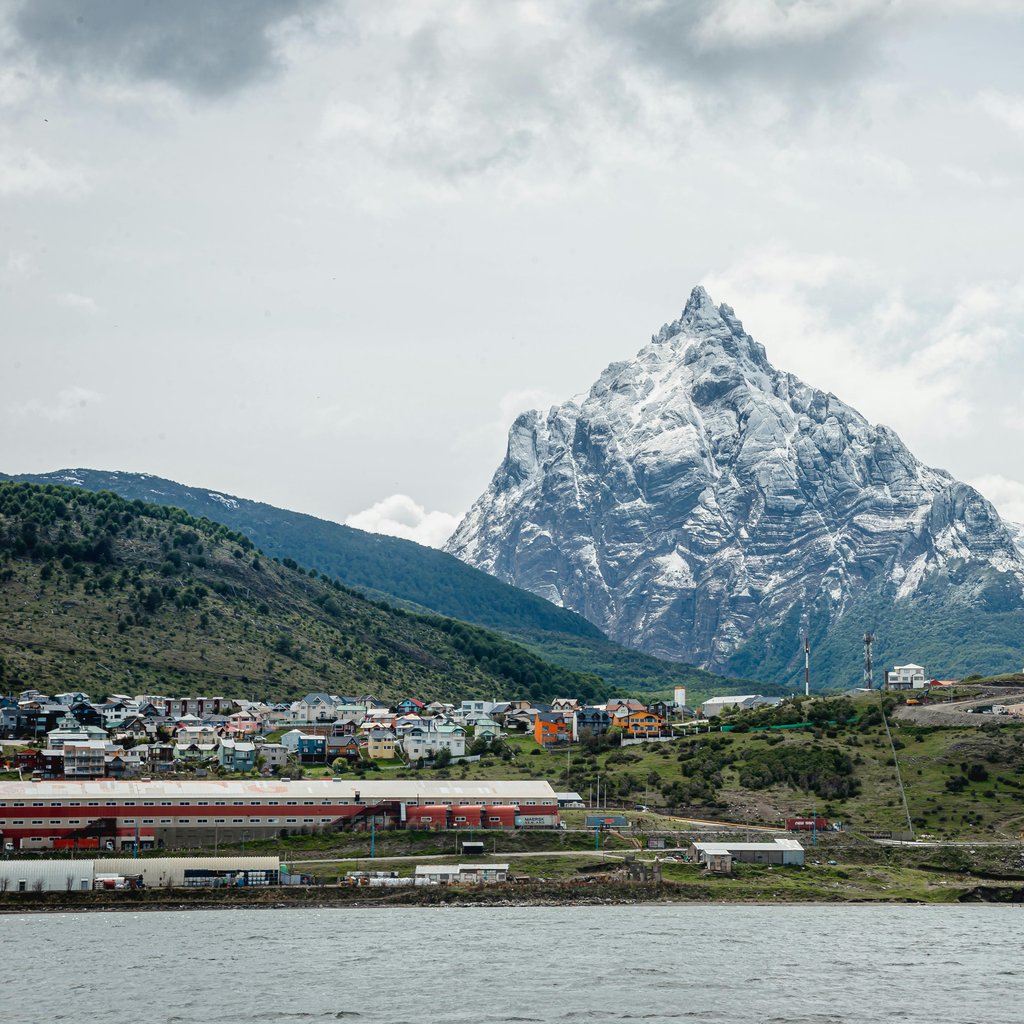 A breathtaking view of the snow-covered mountains towering over the cityscape of Ushuaia, Argentina.