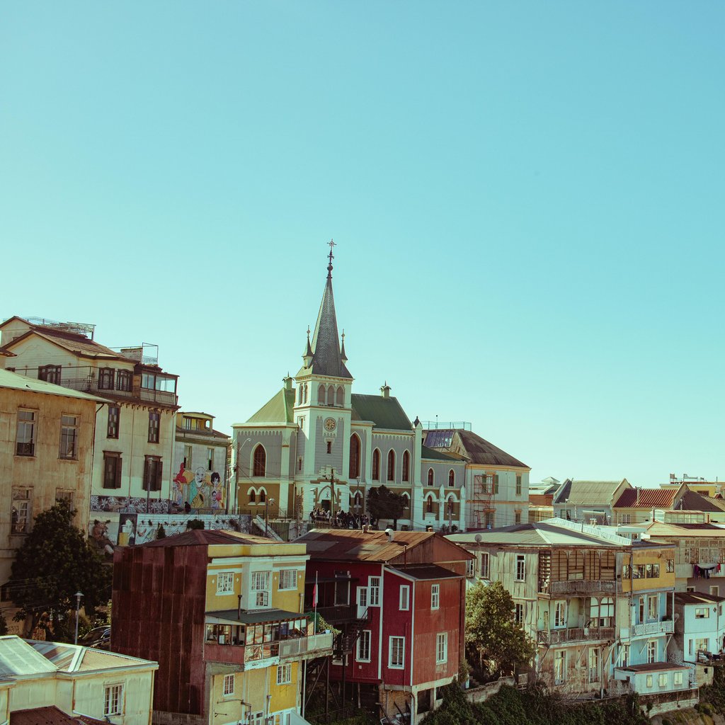 A beautiful view of Valparaíso's colorful houses and sea under a clear sky, capturing the city's charm.