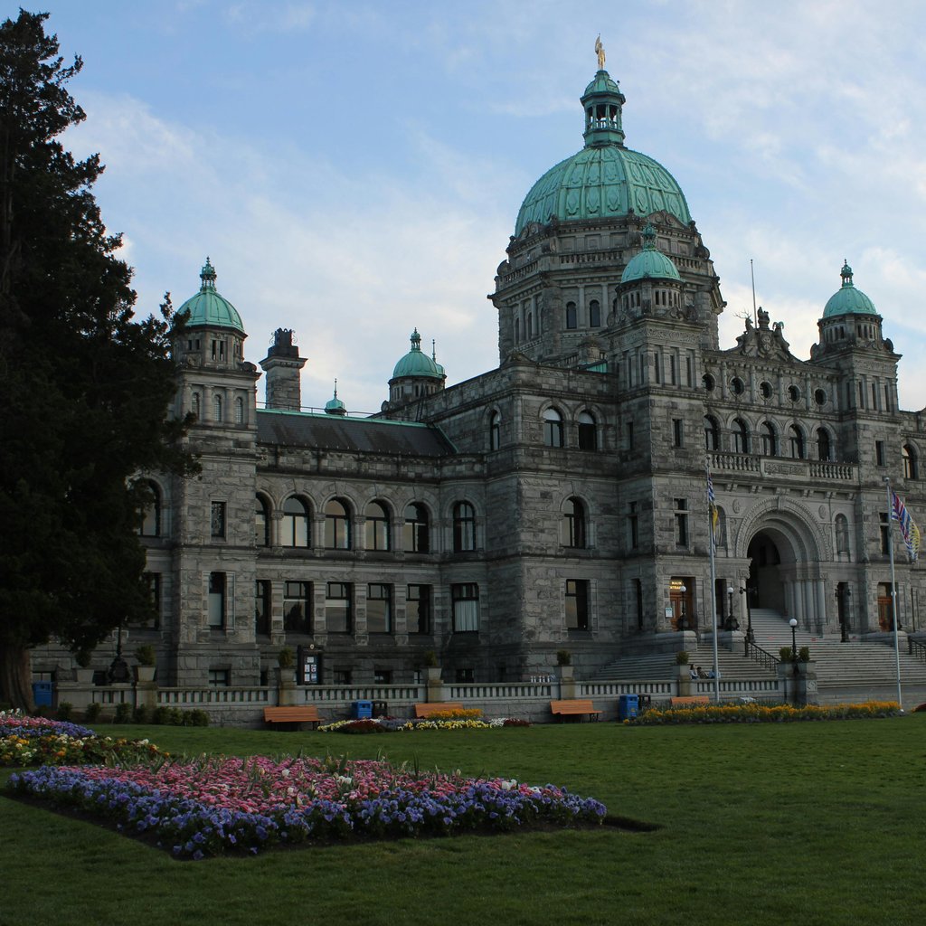 Explore the majestic architecture of the Victoria BC Parliament Building surrounded by lush gardens.