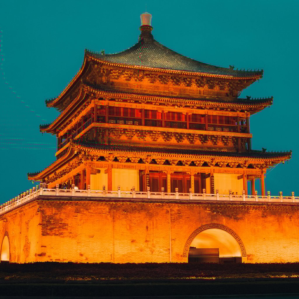 Majestic view of the illuminated Bell Tower in Xi'an, China against a twilight sky.